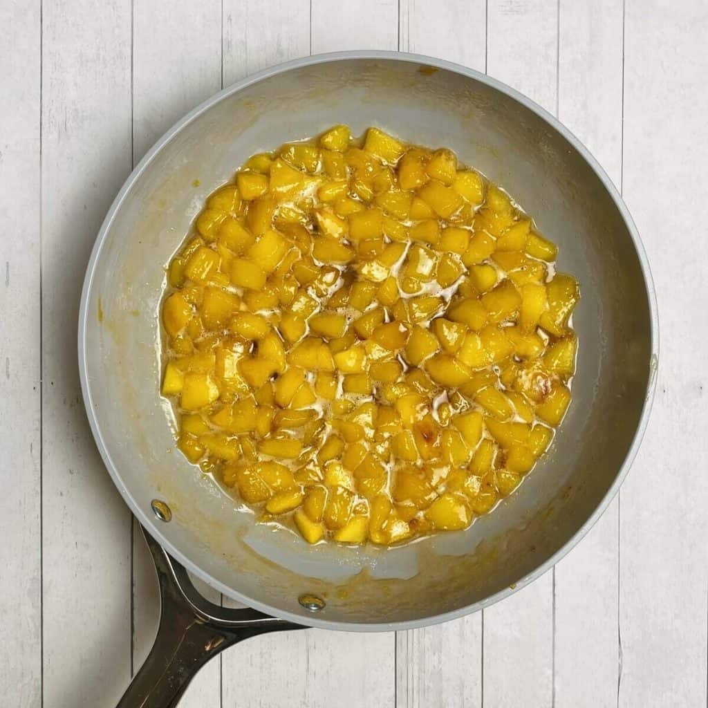 Cooked peach compote in a nonstick skillet.