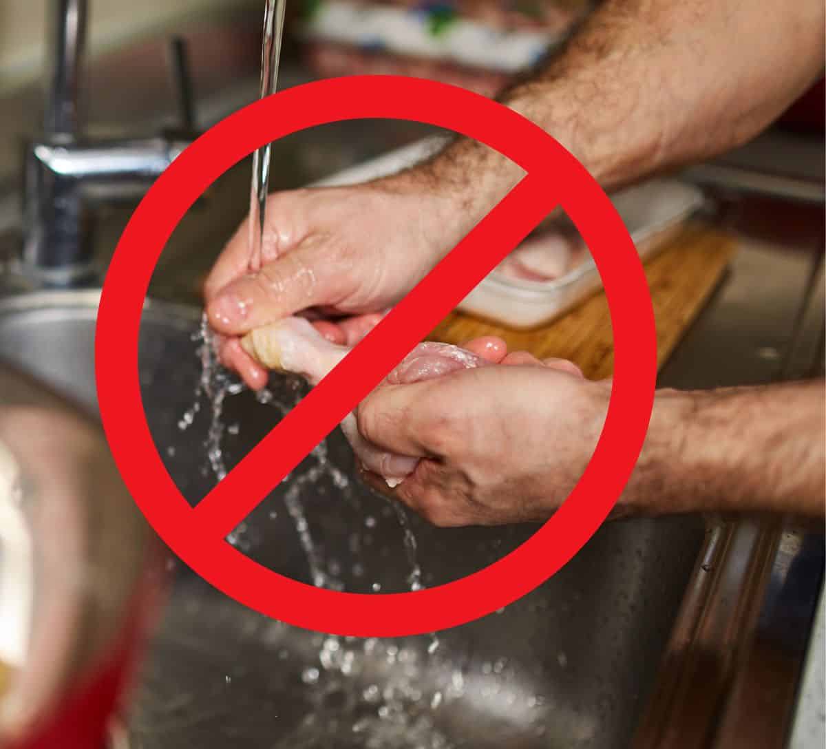 Hands rinsing raw chicken over a sink under running water with a red X placed over the top.