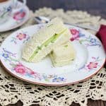 Two cucumber finger sandwiches on a china plate.