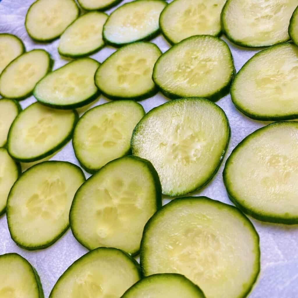 A close up of moisture building on salted cucumber slices.