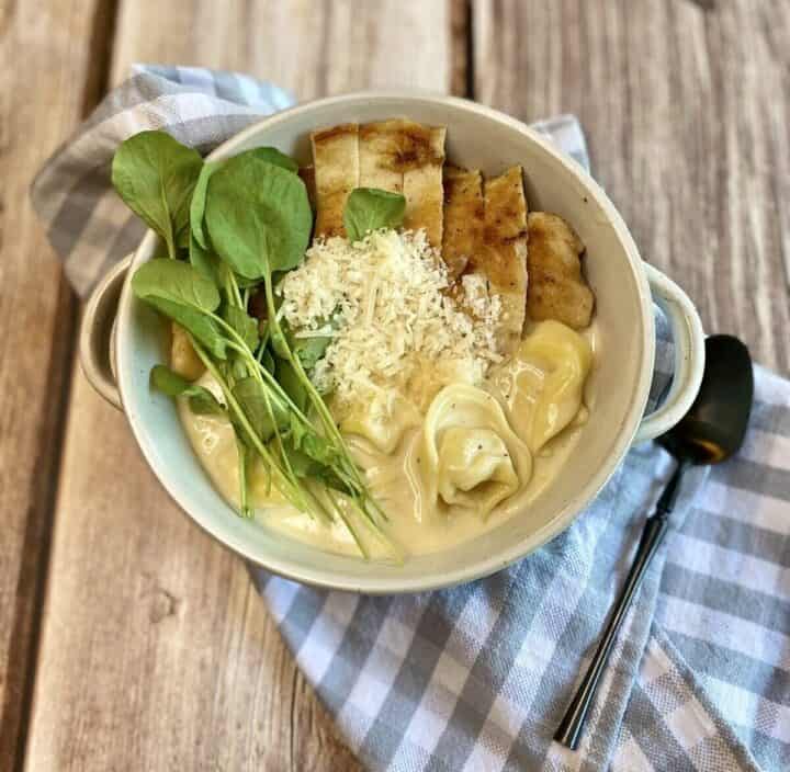 A bowl of soup with a spoon and napkin.