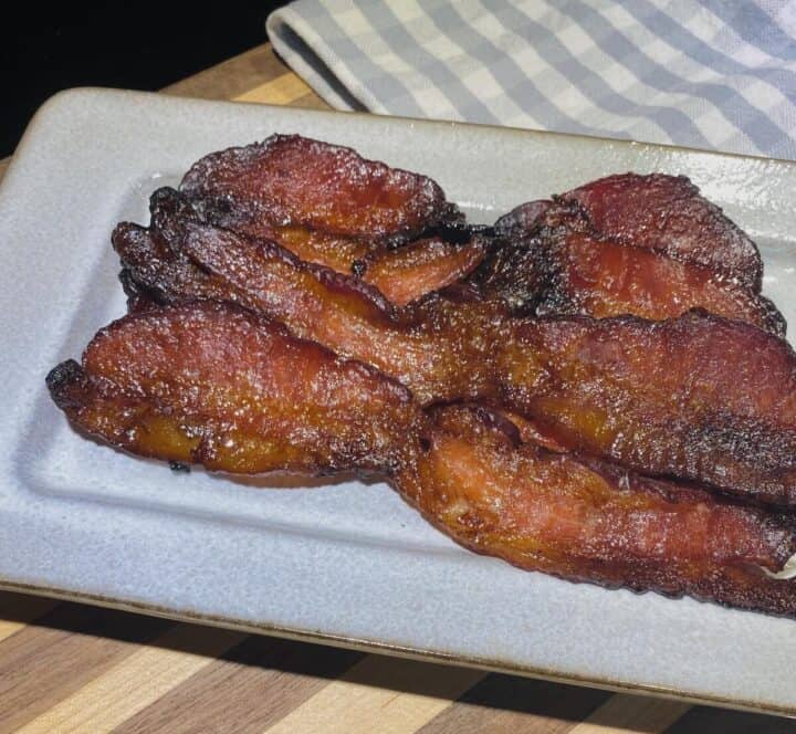 A plate of maple bacon with a napkin.