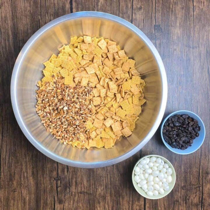 A large bowl and two small bowls holding cinnamon roll crunch mix ingredients.