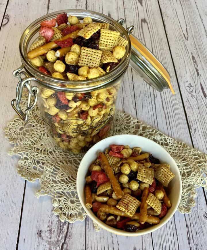 A jar and a bowl of snack mix.