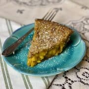 A slice of cardamom apple pie on a blue plate.