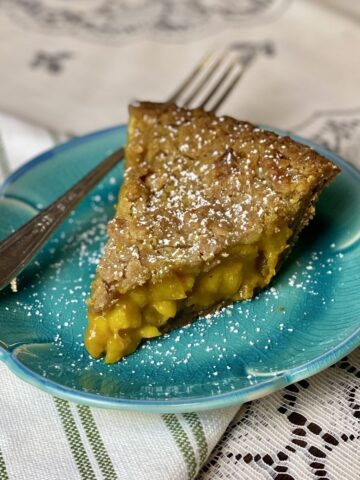 A slice of cardamom apple pie on a blue plate.