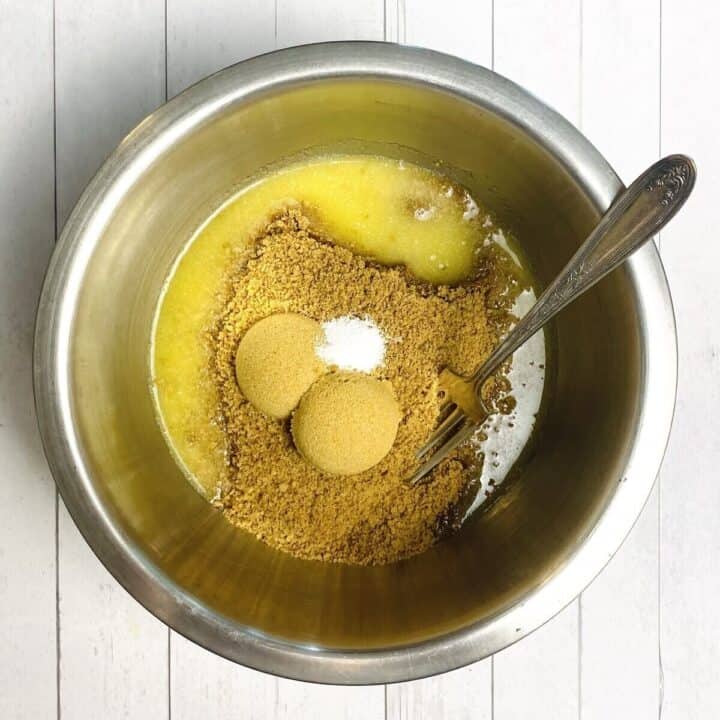 A bowl of gingersnap crust ingredients and a fork.