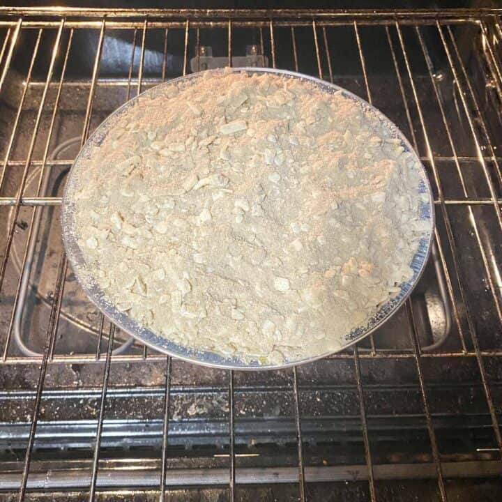 An uncooked pie set on the top oven rack.