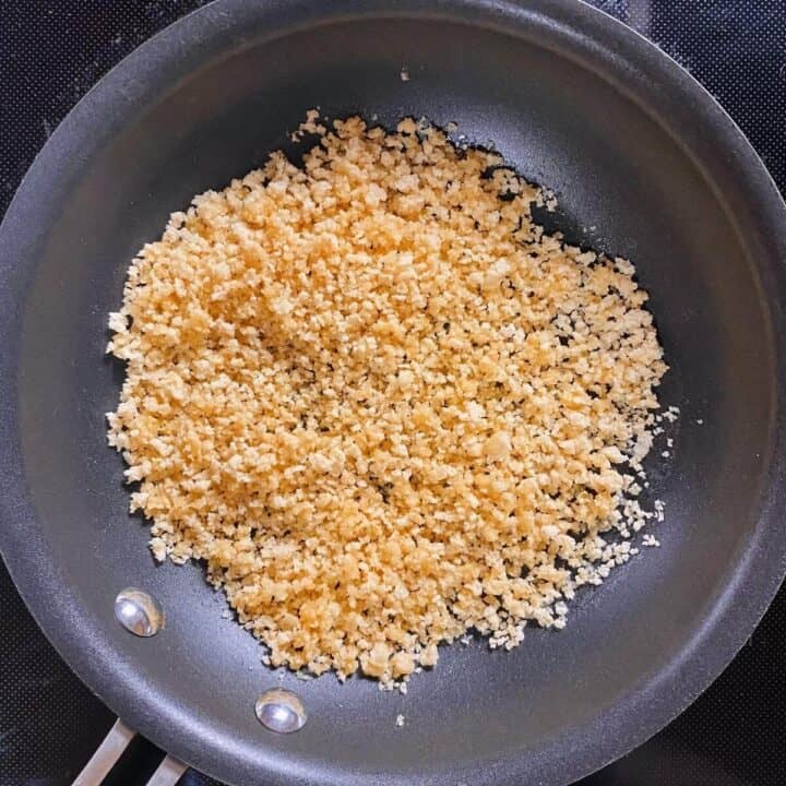 A small nonstick skillet browning panko crumbs in butter.