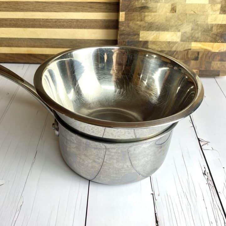 A small bowl sitting on top of a small pot to create a double boiler.