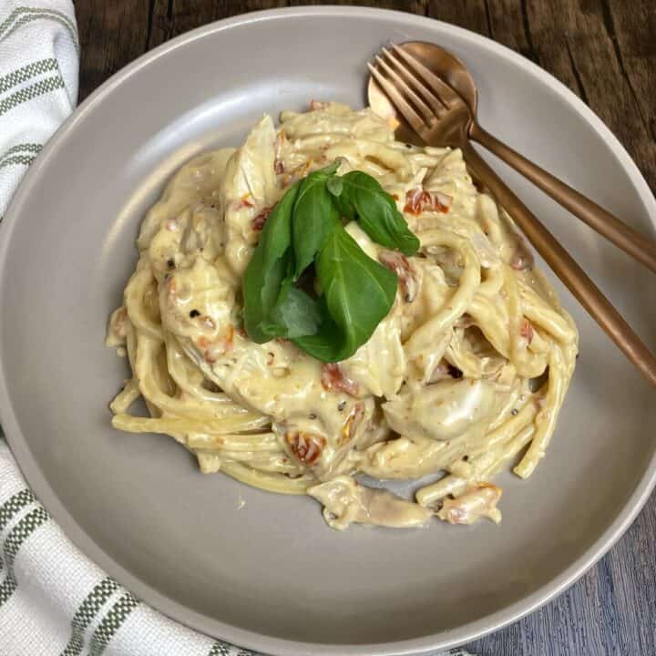 Bowl of marry me chicken pasta with fresh basil on top.