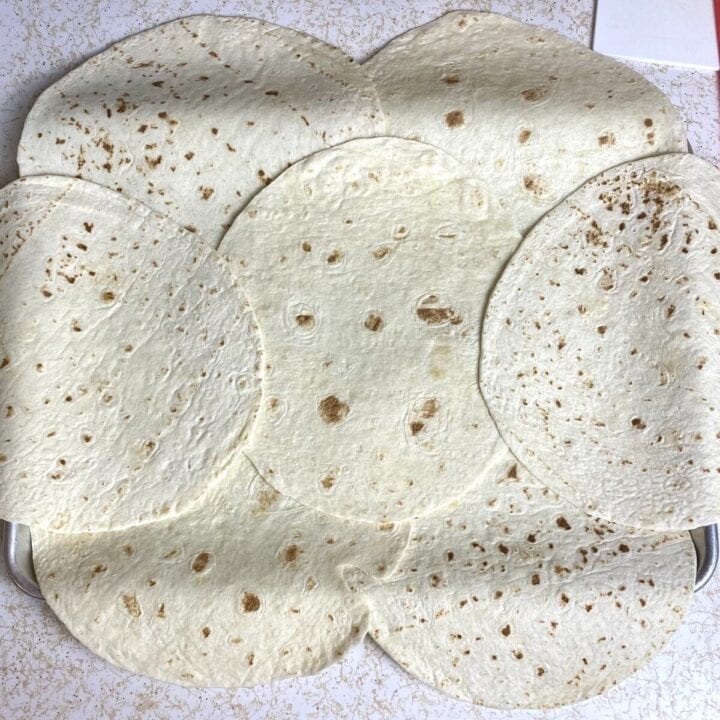 A sheet pan shingled with seven quesadillas.