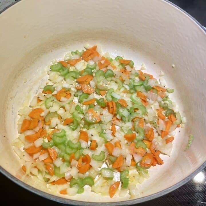 Vegetables sautéing in a pot.