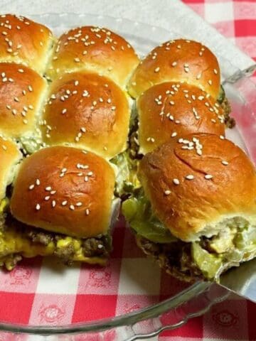 Sliders with cheese and meat on a plate.