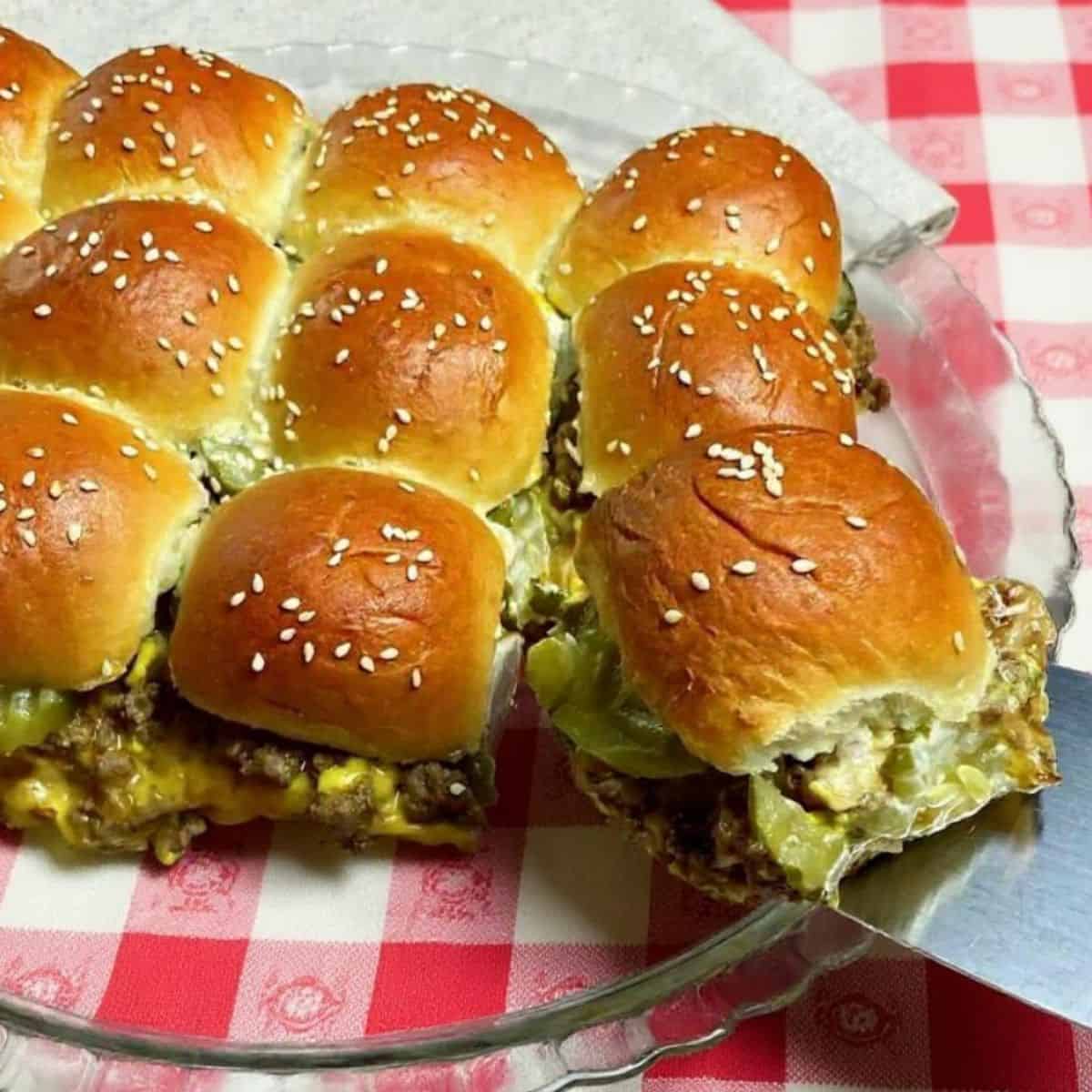 Sliders with cheese and meat on a plate.