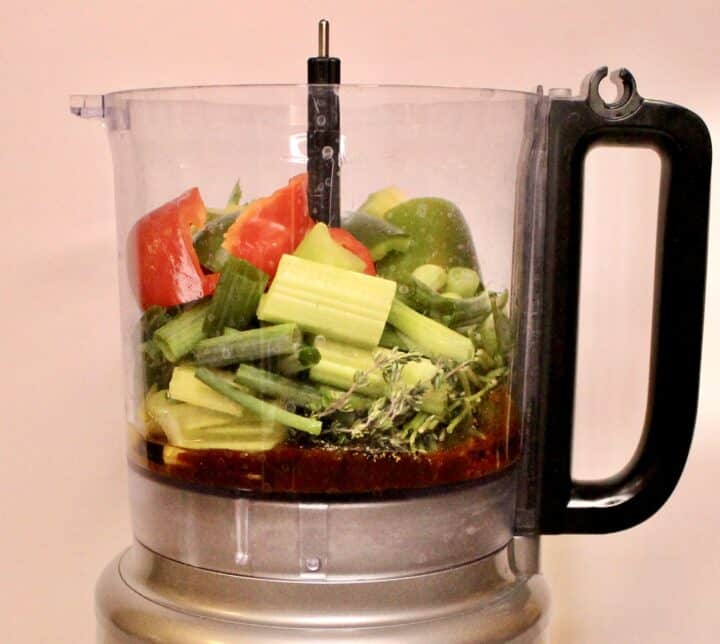 All the ingredients for haitian epis in a food processor.