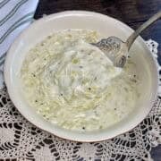 A bowl of leek sauce and a serving spoon.