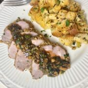 walnut pork tenderloin on a white plate.