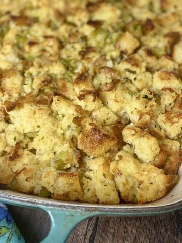 Crispy stuffing casserole with herbs and celery in a cast iron baking dish.