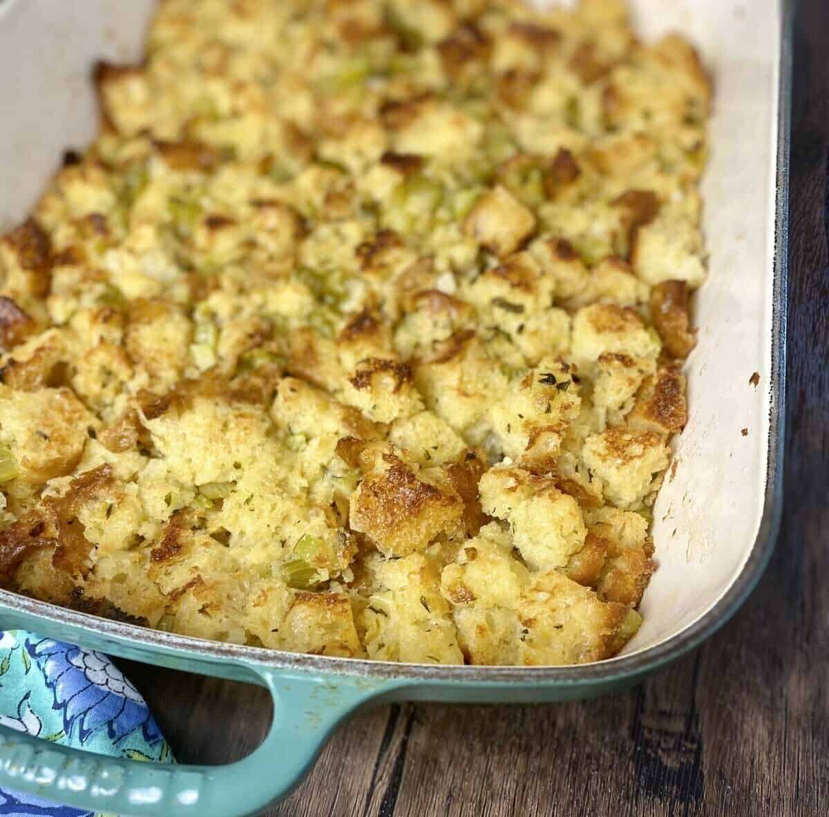 Crispy stuffing casserole with herbs and celery in a glass baking dish.