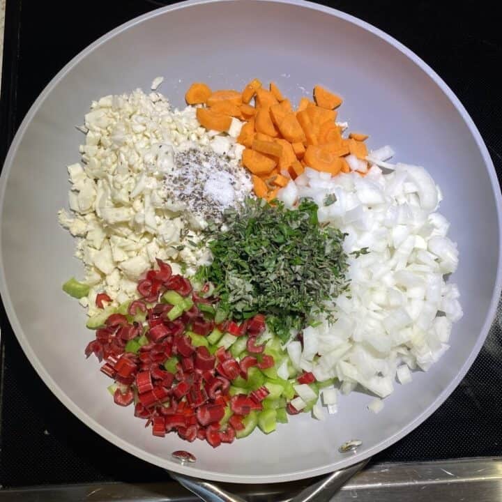 A non-stick pan with raw vegetable ingredients.