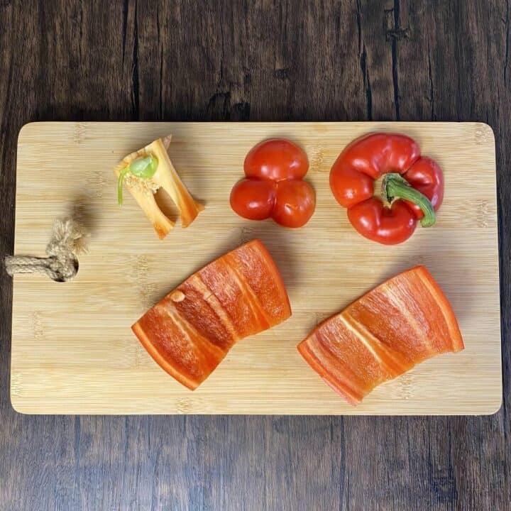 Red bell pepper sliced on a cutting board.