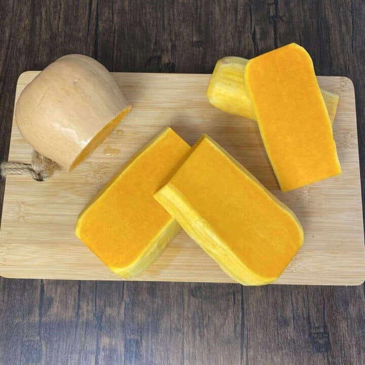 Butternut squash sliced on a cutting board.