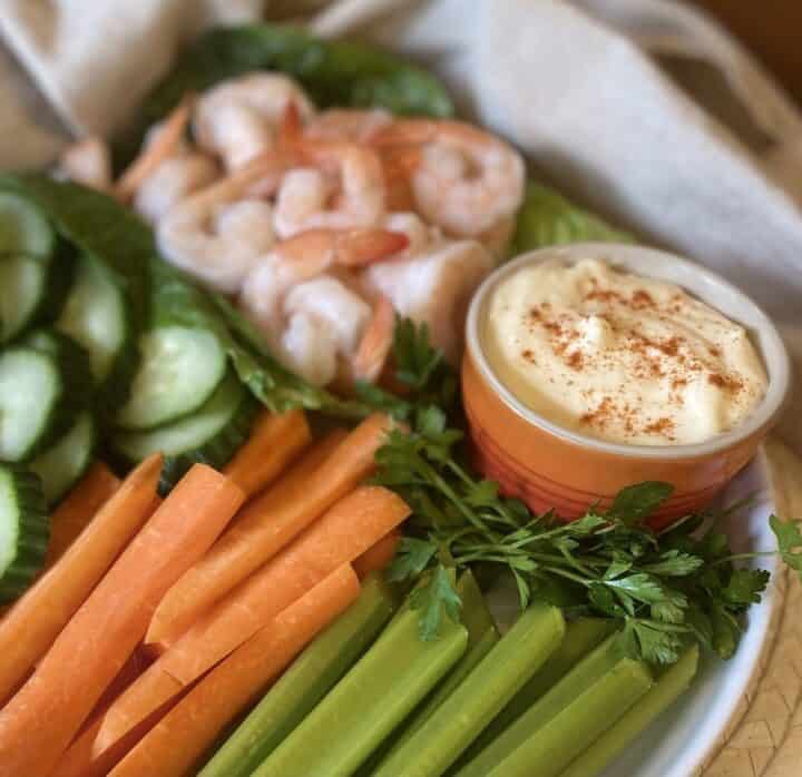 A crudite and shrimp platter with a dish of garlic aioli.